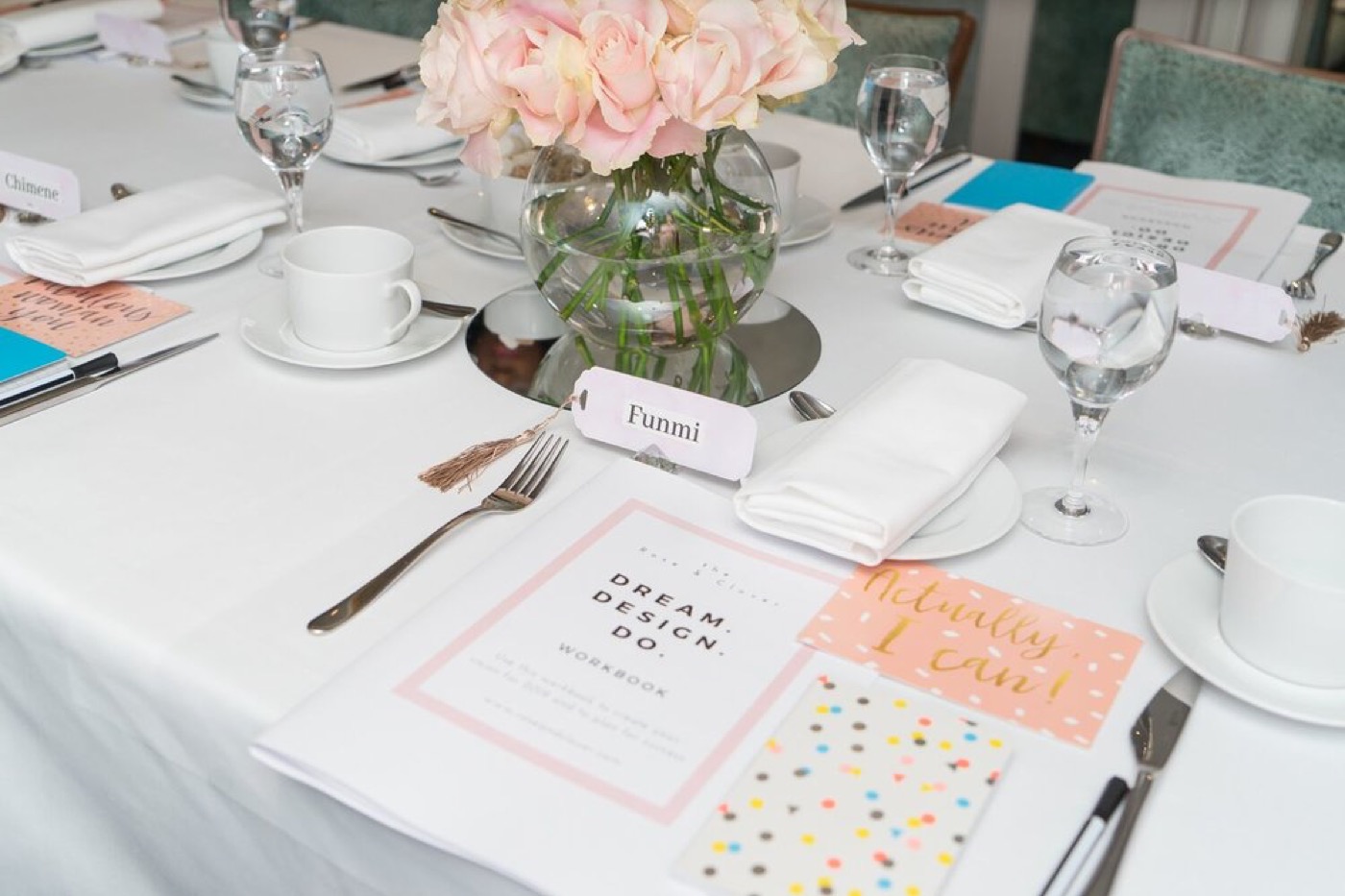 A rose centrepiece beside a place card and workbook