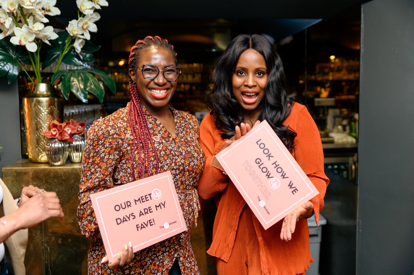 Two people smiling and holding a sign at a past gathering
