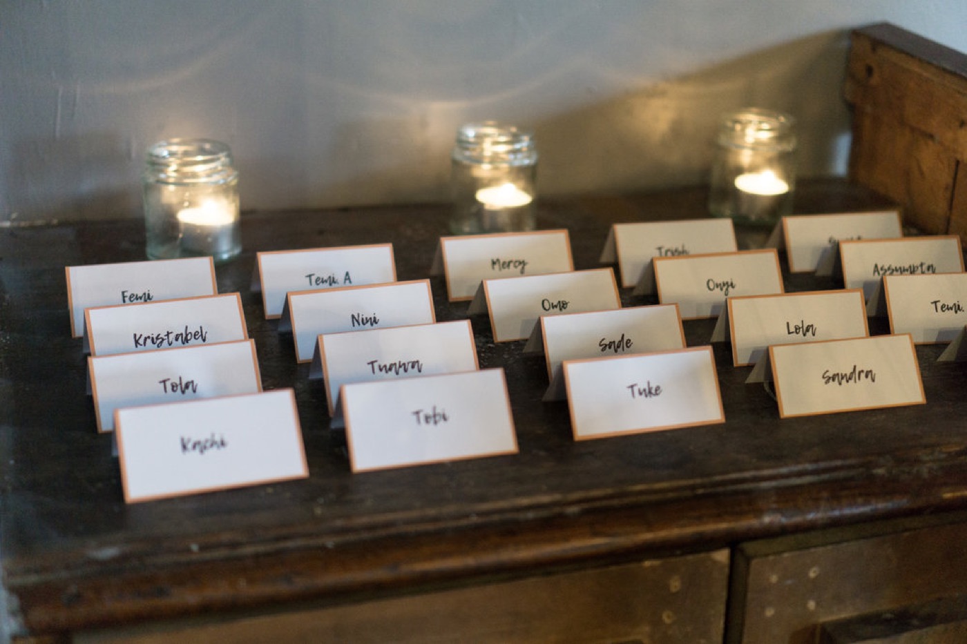 Place cards and candles styled on a wooden table