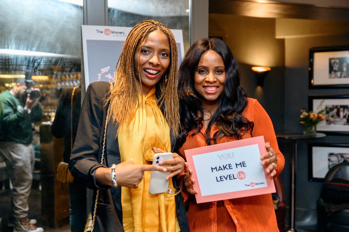 Two people smiling and holding a sign at a past gathering